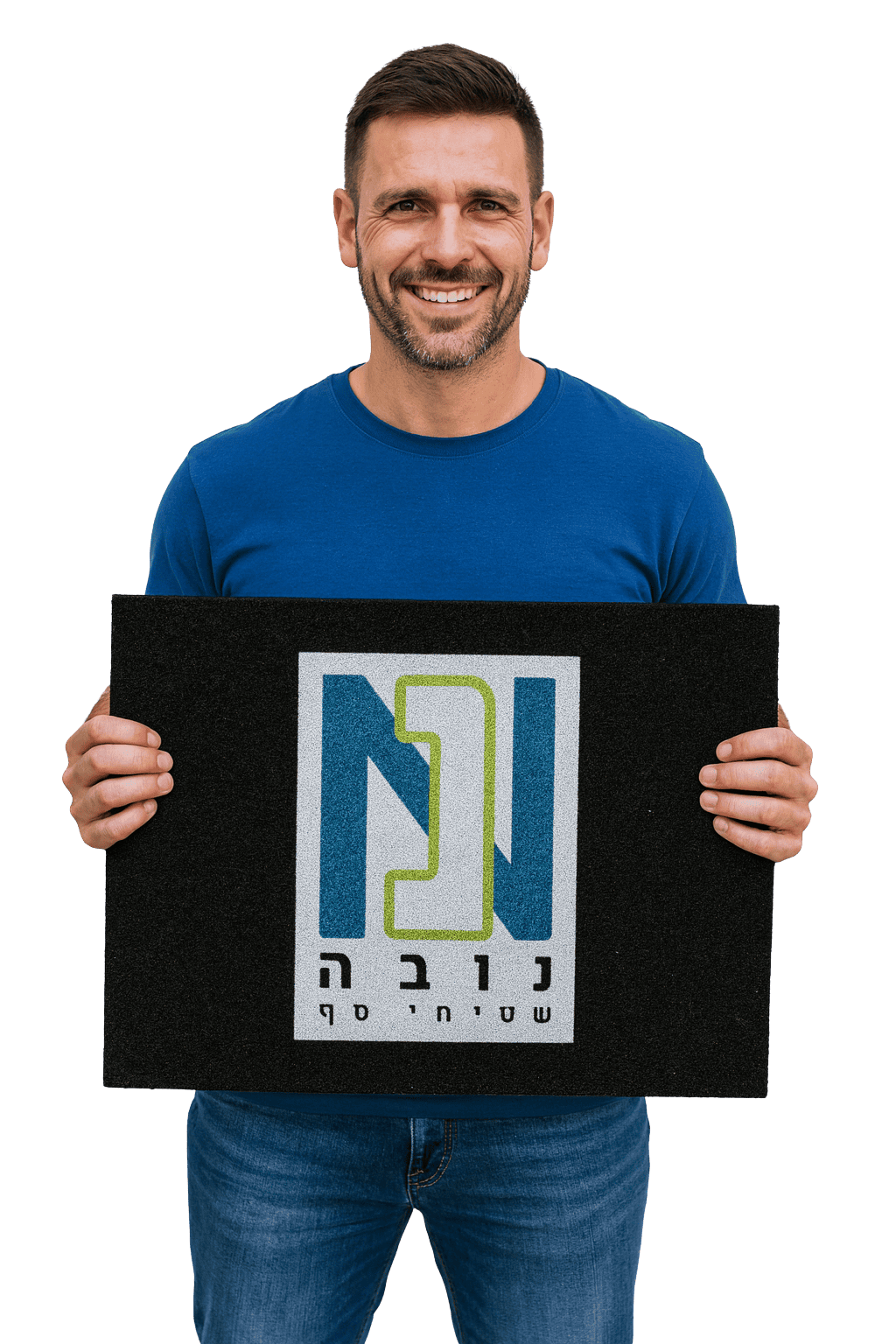 גבר בחולצה כחולה מחייך בזמן שהוא מחזיק מזרן שחור מלבני עם לוגו וטקסט בעברית, הממחיש למה צריך שטיח לעסק.
